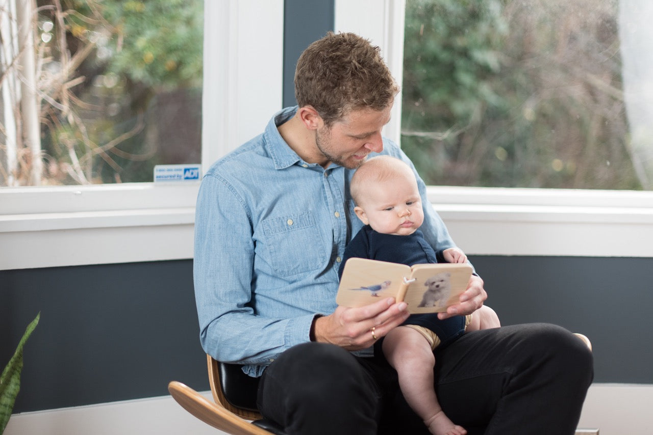 A dad reading the Wooden Book to his baby