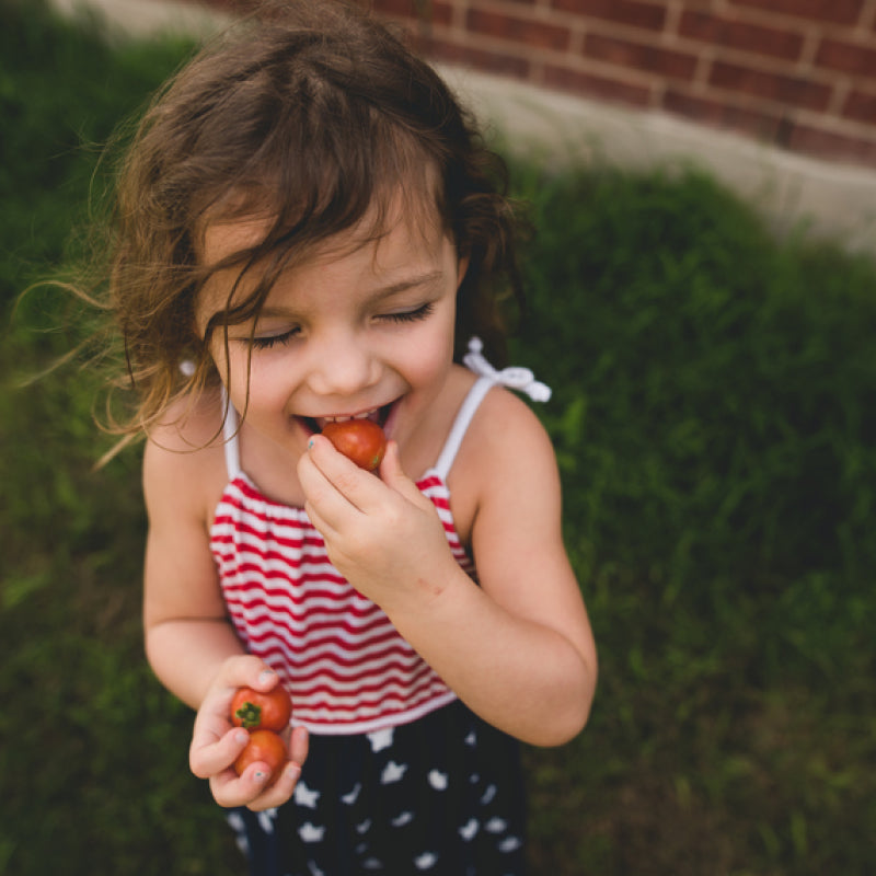 Girl eating a strawberry on the Fourth of July