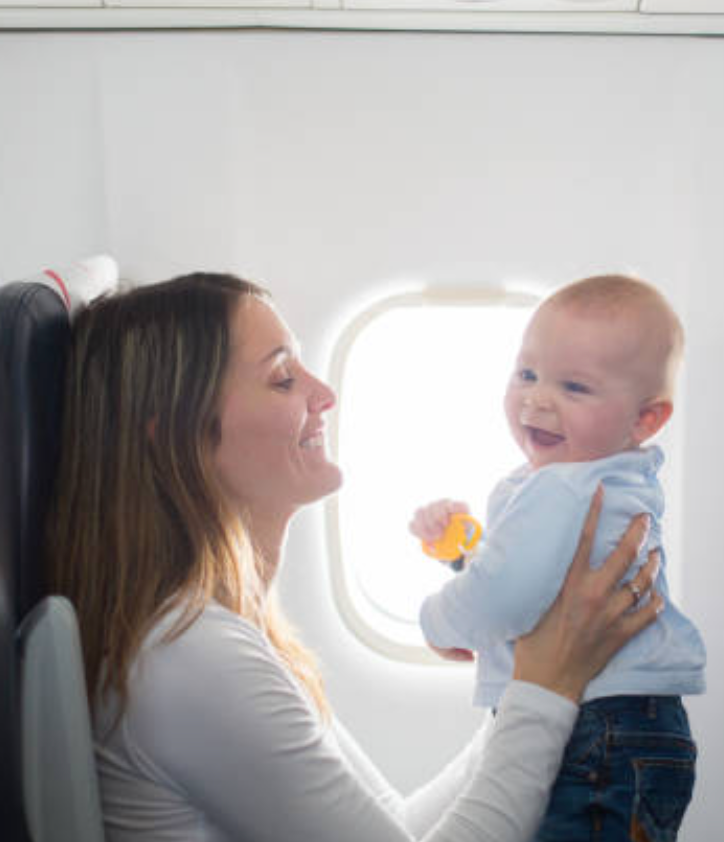 Mom and baby happy on an airplane. Credit Getty